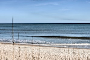 Ein Strand mit blauem Himmel und ruhigem Wasser.