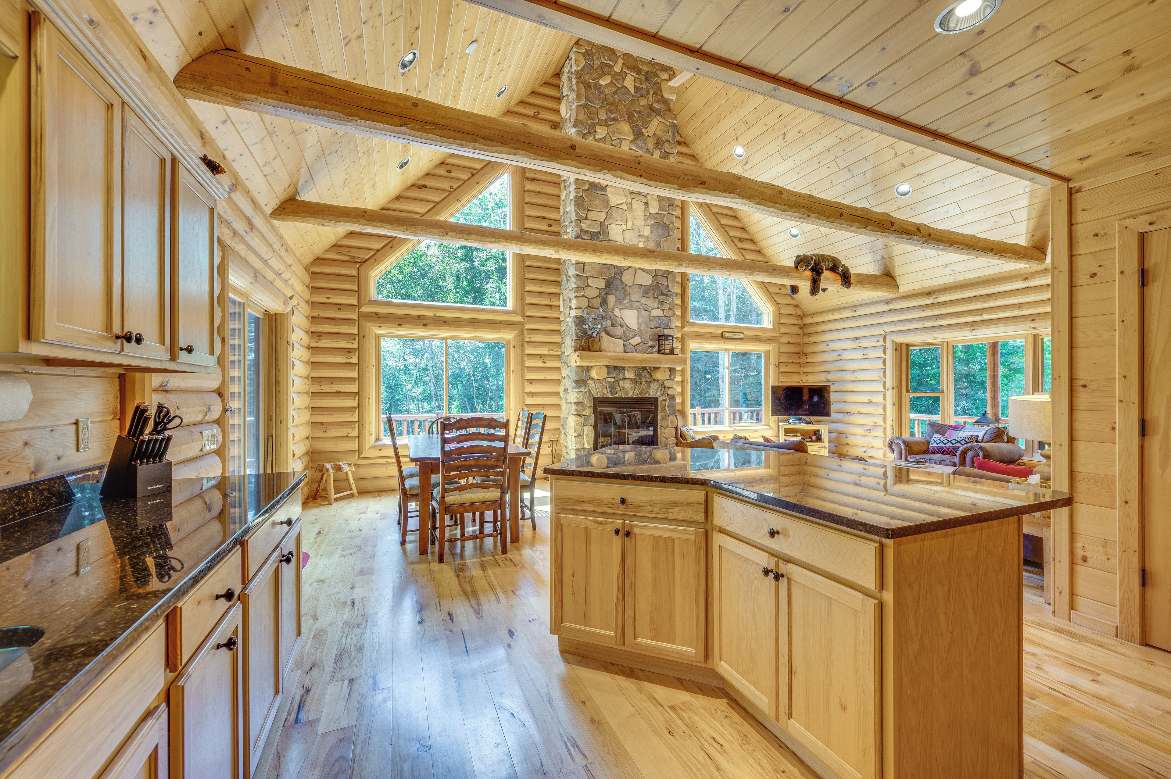 Un intérieur spacieux de chalet en bois, comprenant une grande salle à manger, une cuisine et un coin salon confortable.