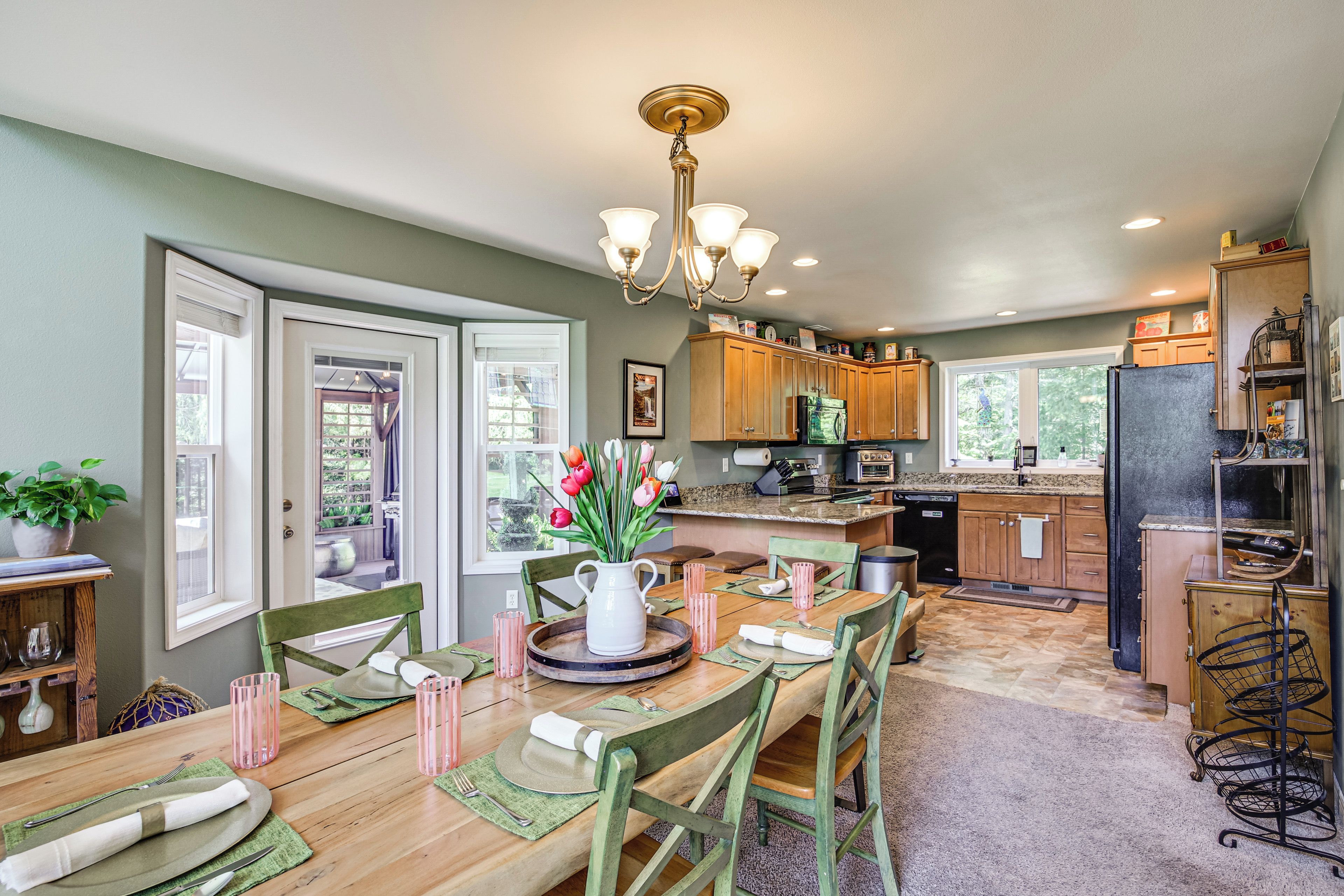 A spacious kitchen with wooden cabinets, a central island, and a dining area with a wooden table and chairs.