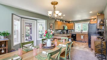 A spacious kitchen with wooden cabinets, a central island, and a dining area with a wooden table and chairs.