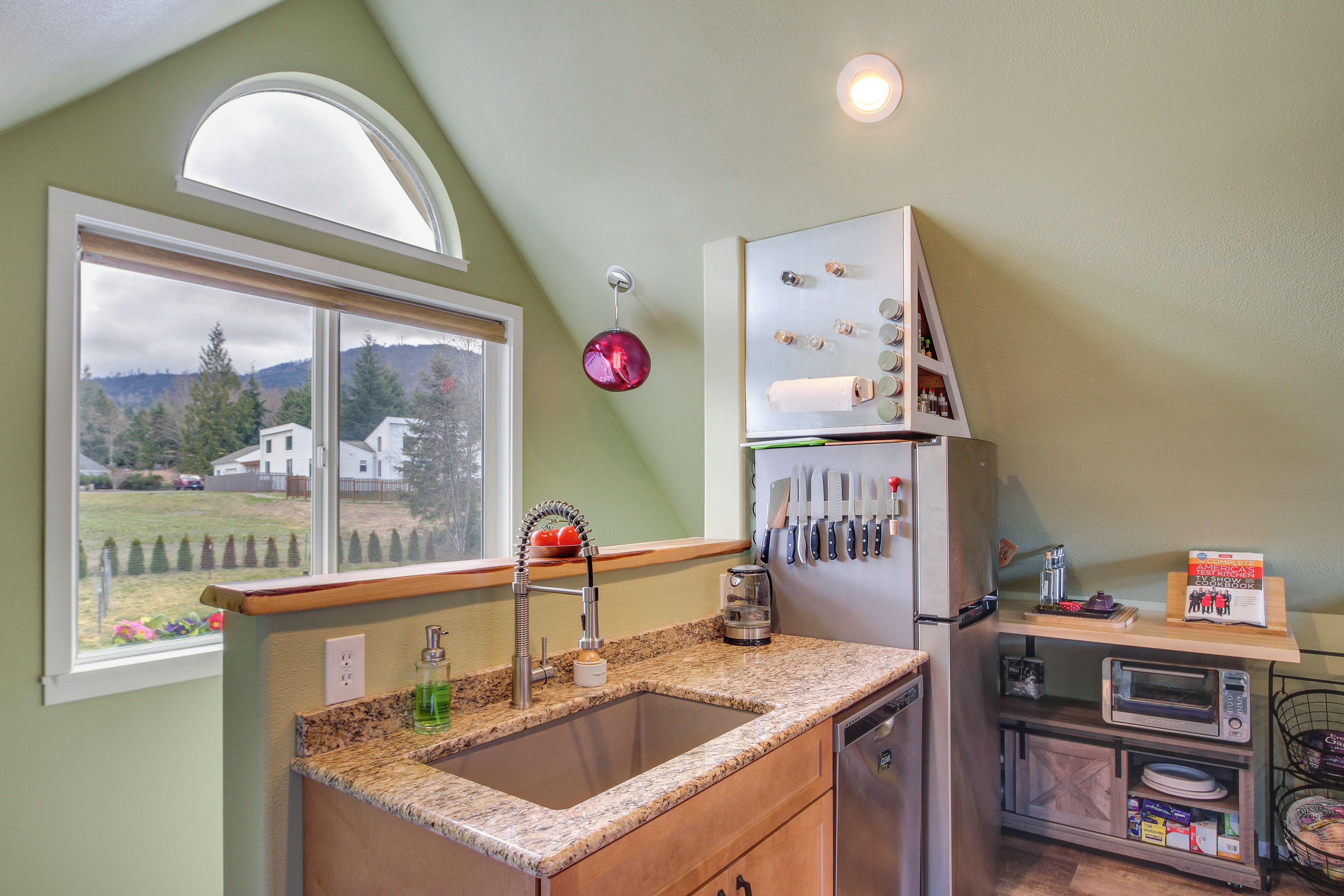 A kitchen with a granite countertop, stainless steel sink, and a built-in oven.