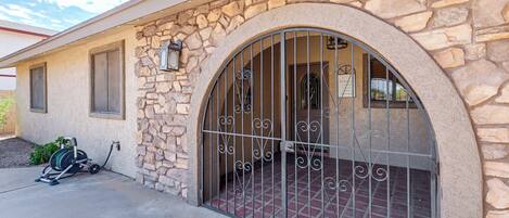 A stone building with a large arched entrance and a metal gate.