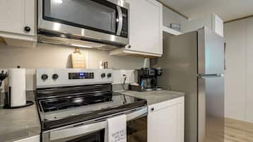 A modern kitchen with stainless steel appliances, including a microwave, oven, and refrigerator.
