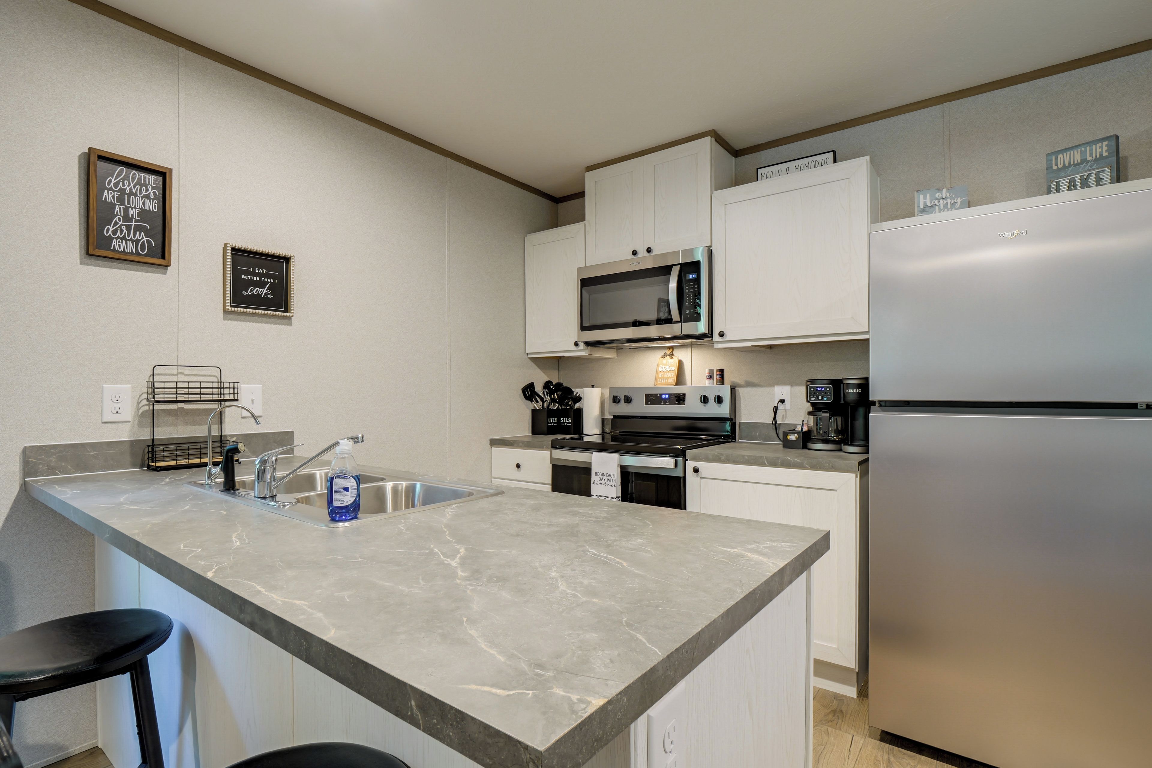 A modern kitchen with a marble countertop, stainless steel appliances, and a built-in oven.