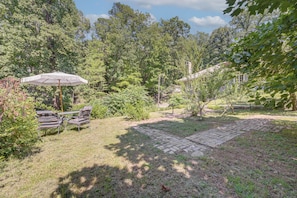 A garden with a patio table and chairs, surrounded by trees and a brick pathway. - Tryon Equestrian Home Near Wine Country & Hiking (Tryon)