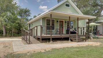 A single-story house with a porch, a small deck, and a front door.