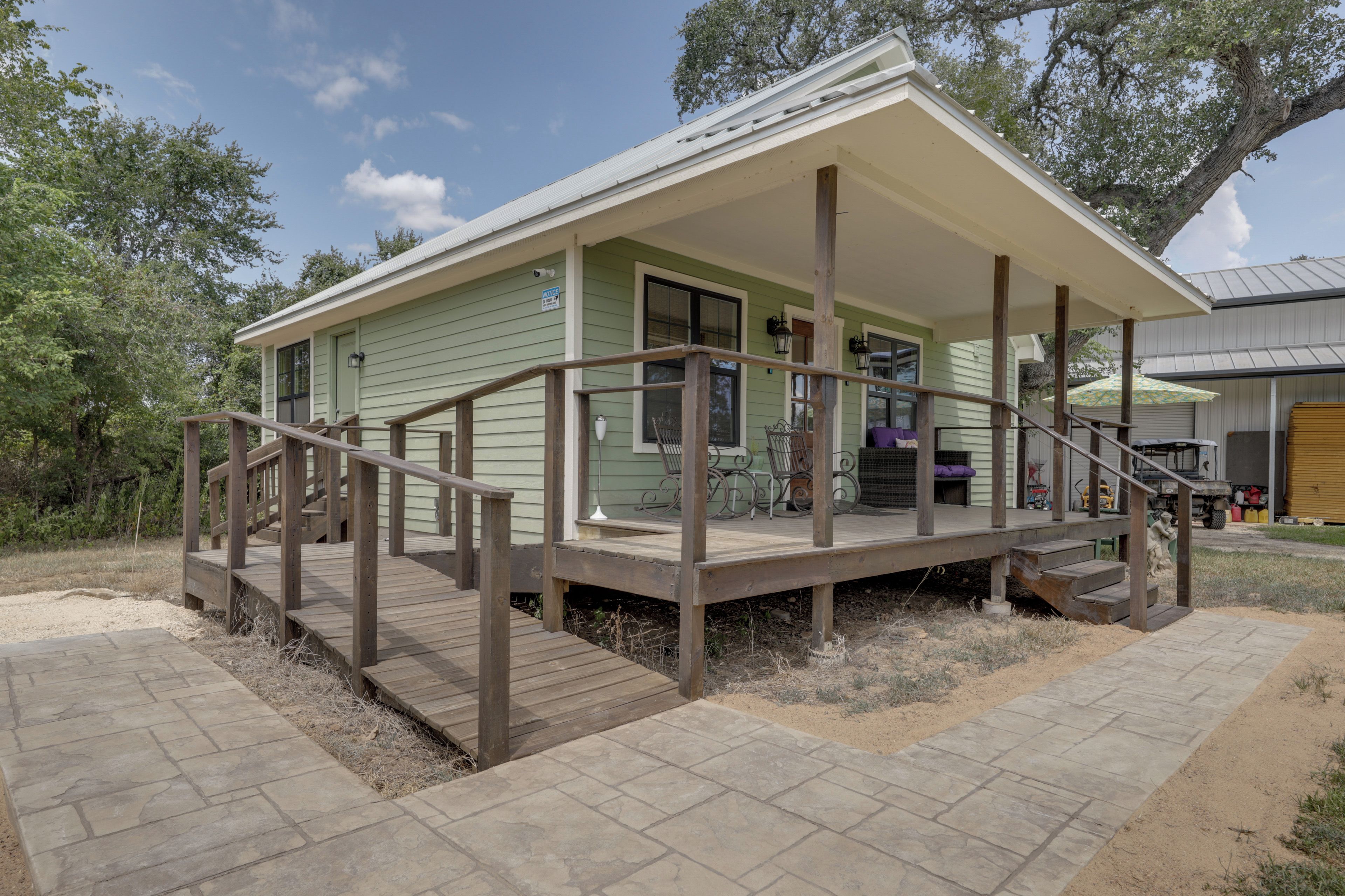 A two-story building with a covered porch and a wooden staircase.