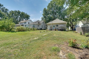 A residential area with multiple houses, a grassy yard, and a wooden fence.