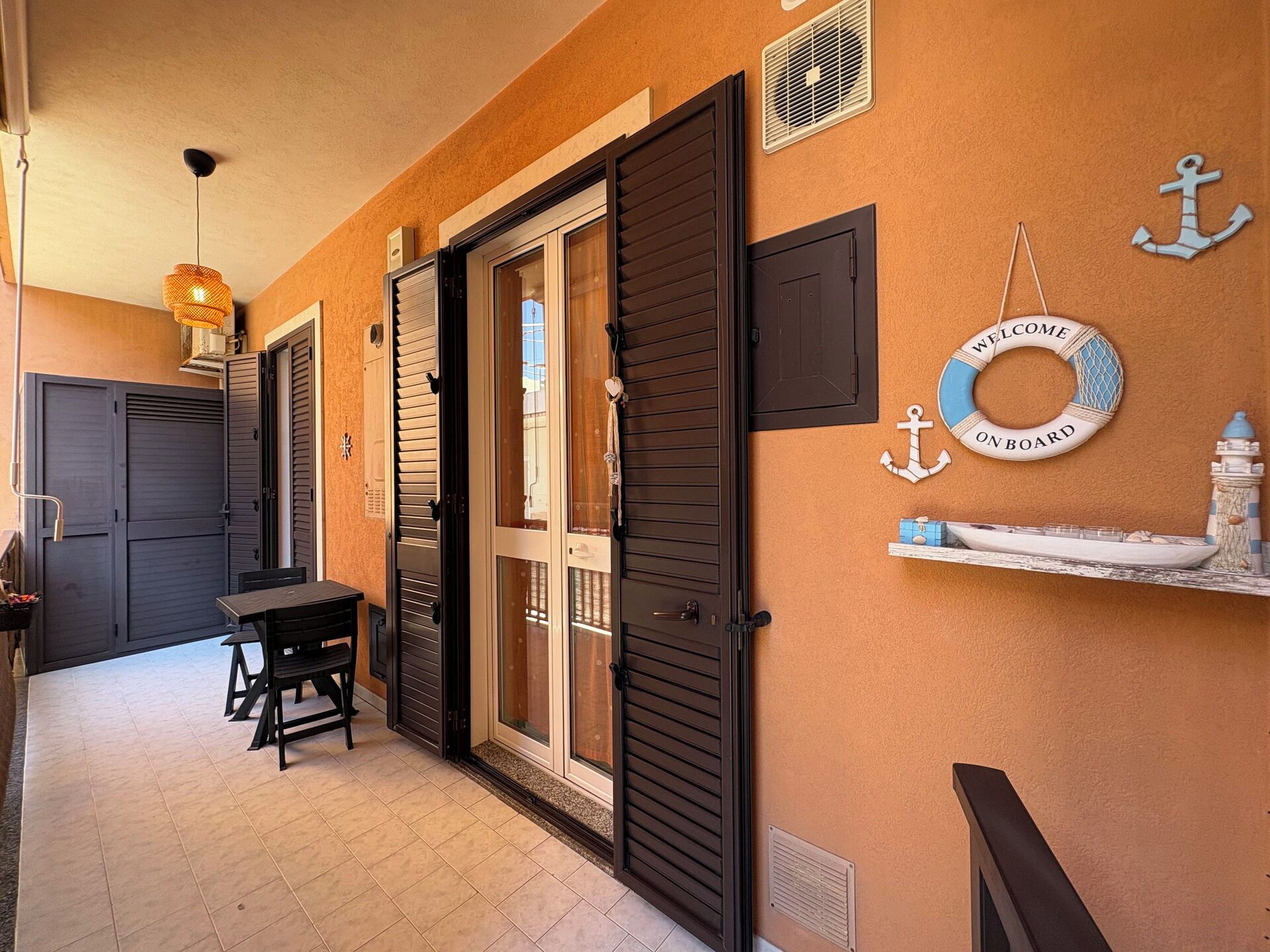 Un couloir avec un banc, une table et une porte dotée d’un panneau en verre.