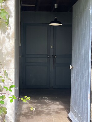 Una porta che dà su una stanza con una lampada a sospensione.