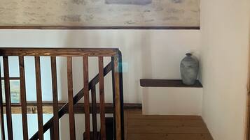 Un escalier en bois, avec un plafond rustique et une petite fenêtre.
