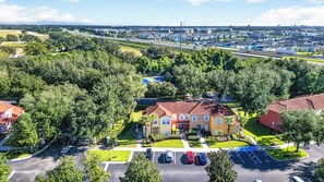 A residential area with a central building surrounded by trees and a parking lot. - PROMO Lovely 3 BR Villa, Resort Access - by Blue Sky Villas (Kissimmee)