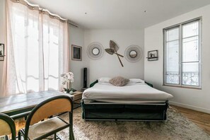 A bedroom with a bed, a desk, and a chair. There are wall decorations and a window with blinds. - Charming Apartment - 2br/6p - Montreuil Near Paris (Montreuil)