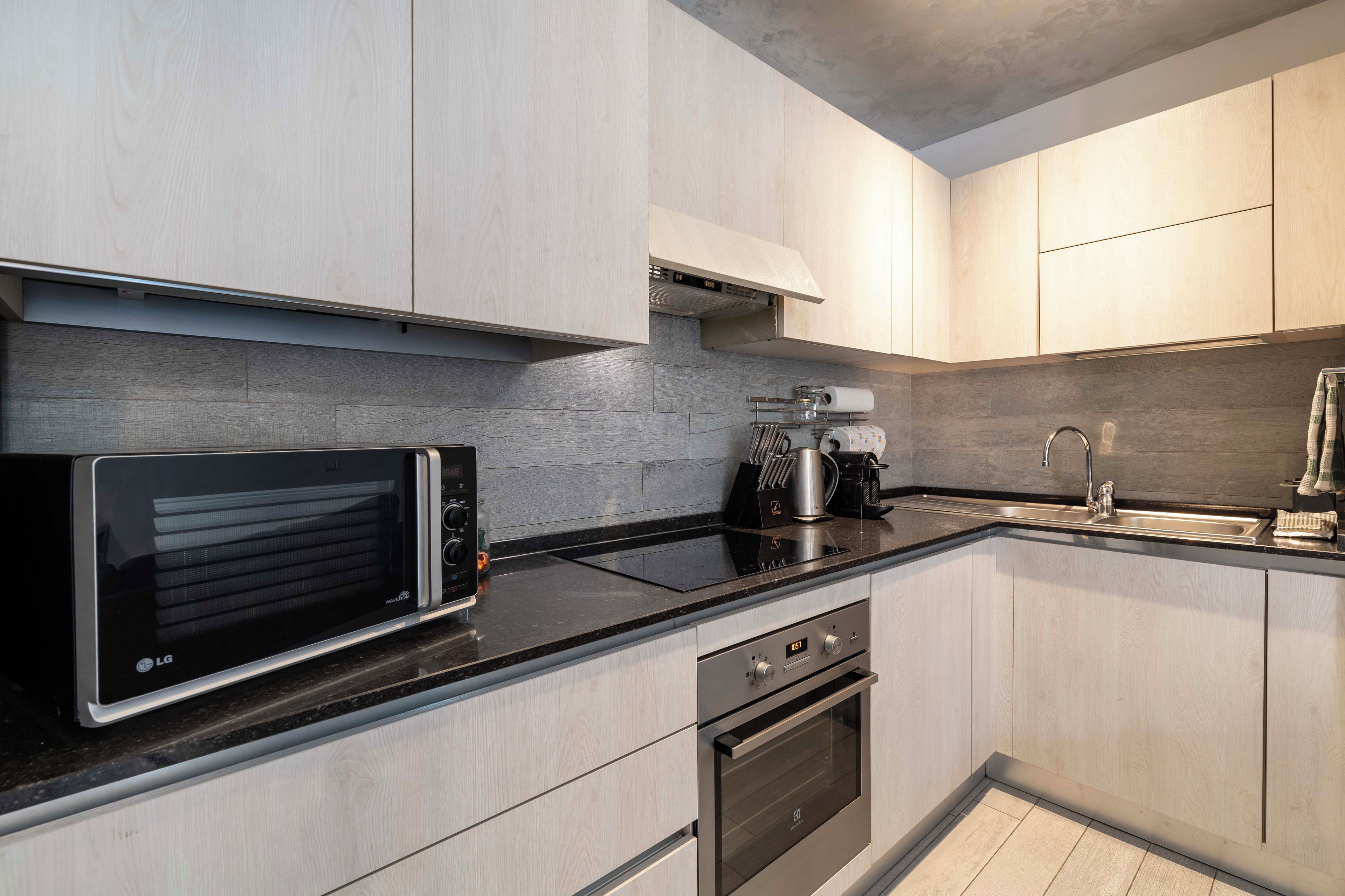 Une cuisine moderne équipée d’un four à micro-ondes, d’une cuisinière, d’un four et d’un évier.