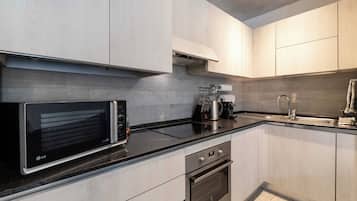 Una cucina moderna con forno a microonde, piano cottura, forno e lavello.