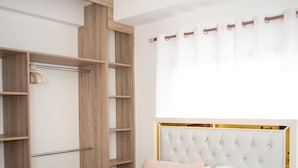Ein Schlafzimmer mit einem Bett, einem Kleiderschrank und einem Deckenventilator.