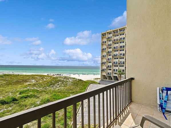 Ein Balkon mit Blick auf den Strand und das Meer.