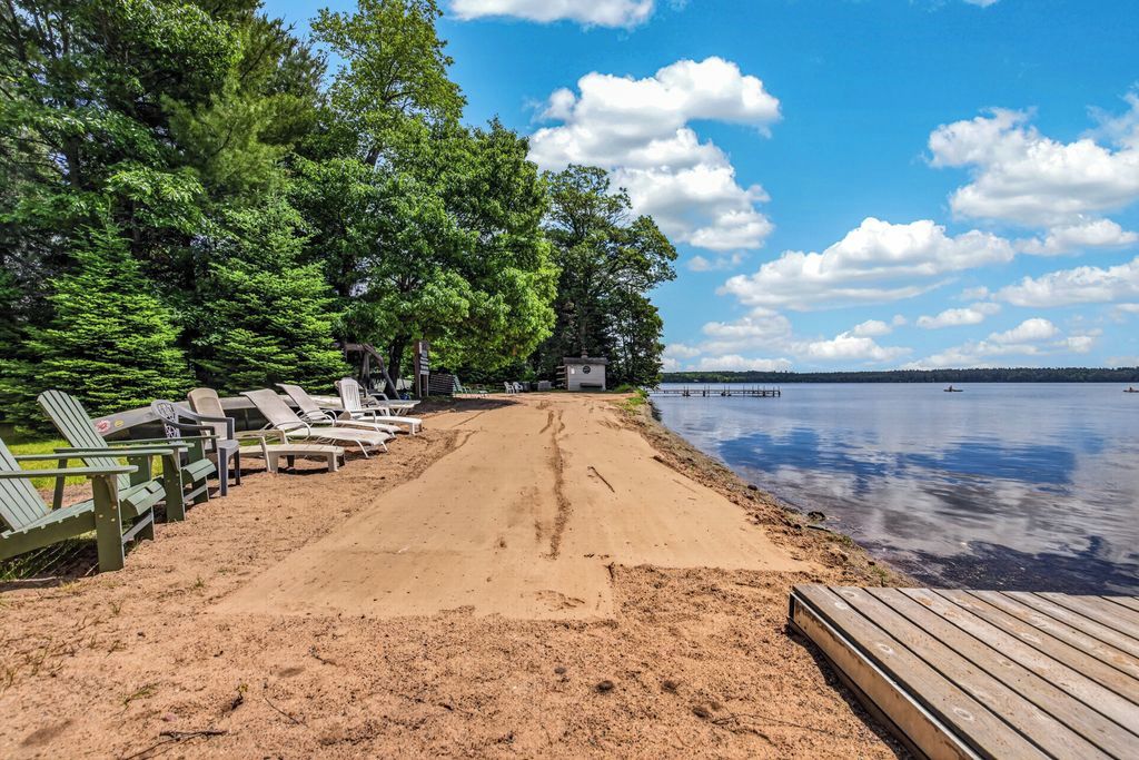 Ein Strand mit Liegestühlen und einer Holzterrasse.