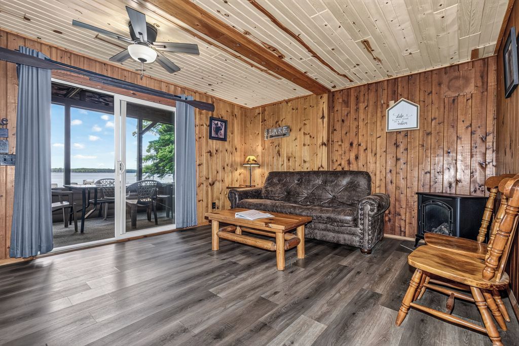 Ein Zimmer mit Holzwänden, einer Couch, einem Couchtisch und einem Kamin.