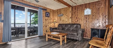 Ein Zimmer mit Holzwänden, einer Couch, einem Couchtisch und einem Kamin.