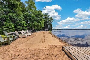 A beach with lounge chairs and a wooden deck. - Stepaway Vacation Rentals/Hillcrest Cottages-Maple (St.Germain)