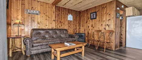 Un intérieur en bois avec un canapé en cuir, une table basse en bois et une cheminée.