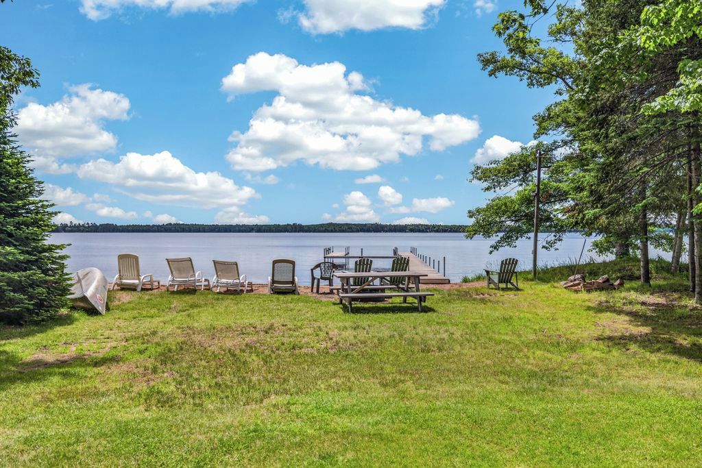 A lakeside deck with outdoor seating and a view of the lake.