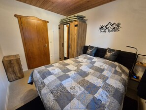 Ein Schlafzimmer mit einem großen Bett, einem Holzschrank und einer Wanddekoration.