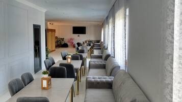 Un comedor moderno con una mesa larga y diversas opciones de asiento, incluyendo un sofá y sillas.