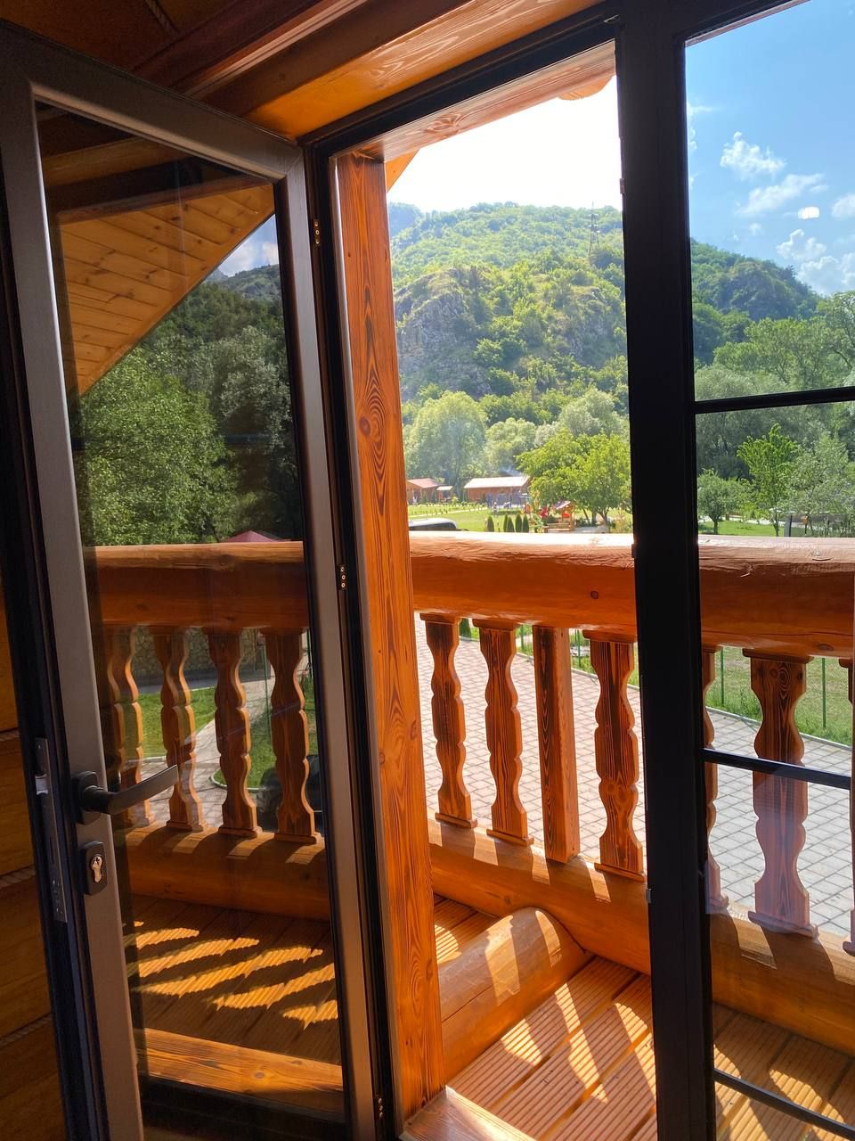 A wooden balcony with a view of a mountainous landscape.