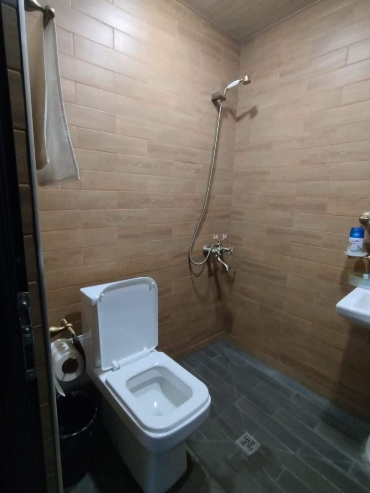 Une petite salle de bain avec des toilettes, une douche et un lavabo.