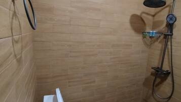 Un baño pequeño con inodoro, bidé y ducha.