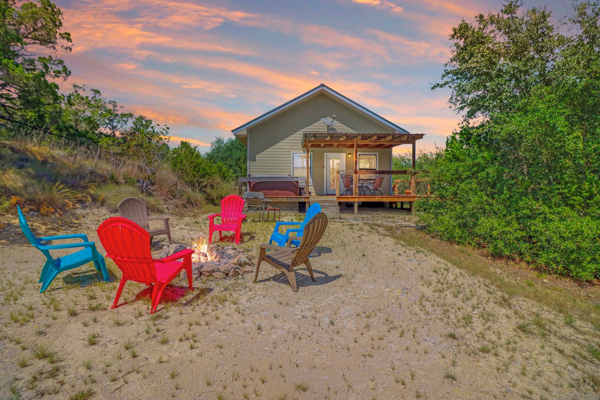 A house with a deck, outdoor seating, and a fire pit.