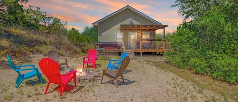 A house with a deck, outdoor seating, and a fire pit.