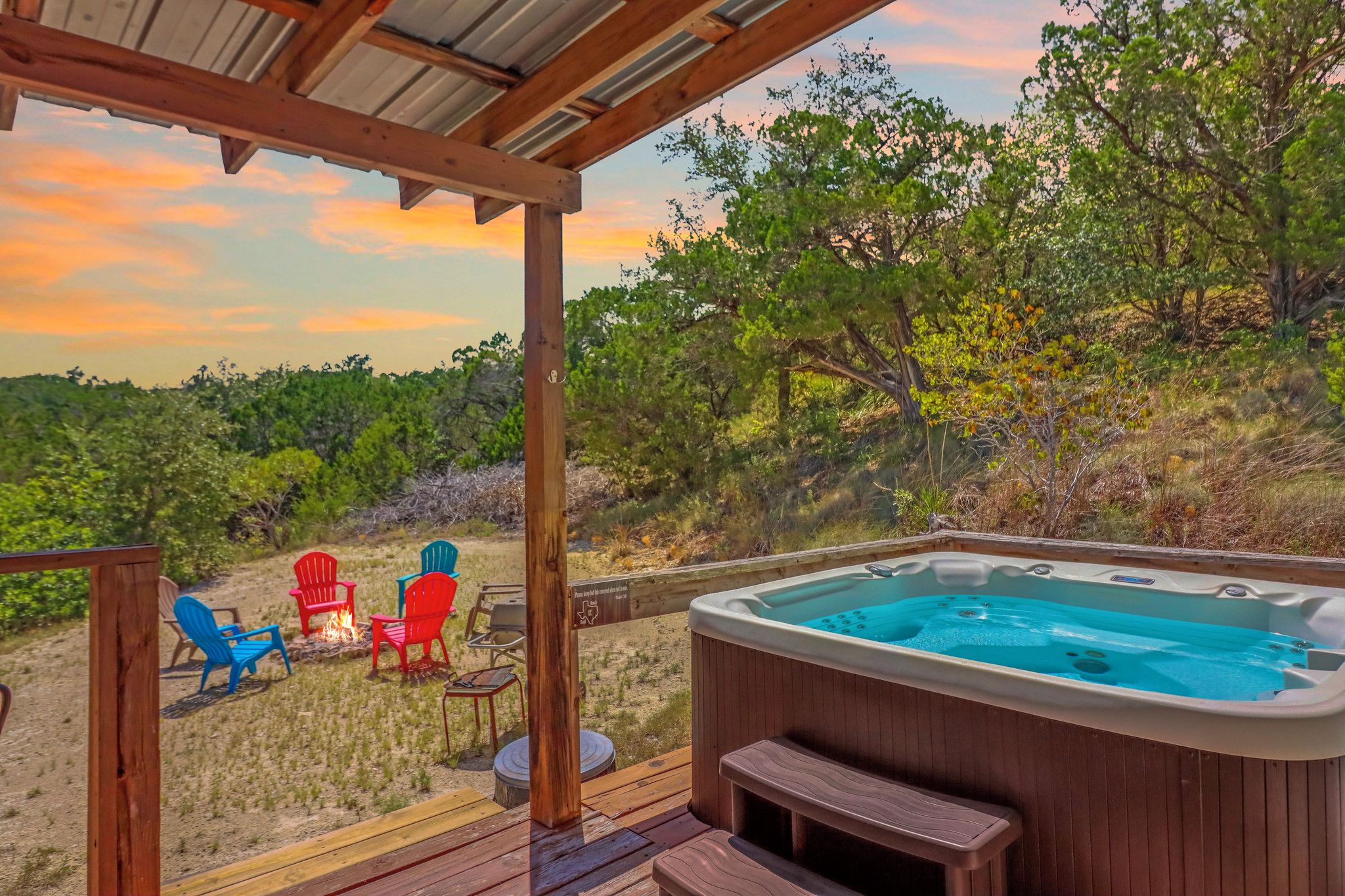 A hot tub on a wooden deck with a view of a forested landscape.