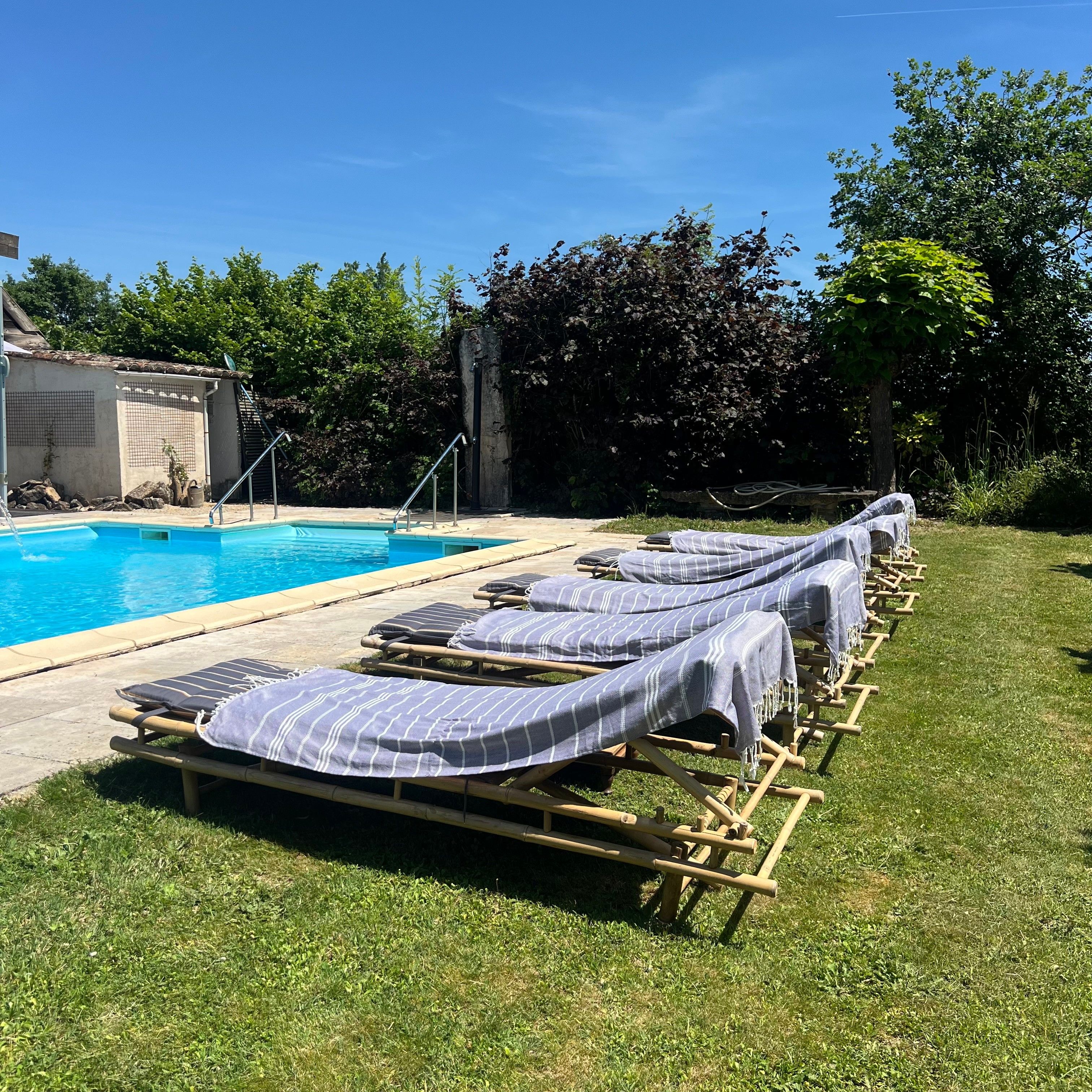 Uma área à beira da piscina com espreguiçadeiras e piscina.