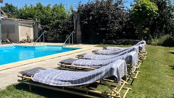 A poolside area with lounge chairs and a pool.