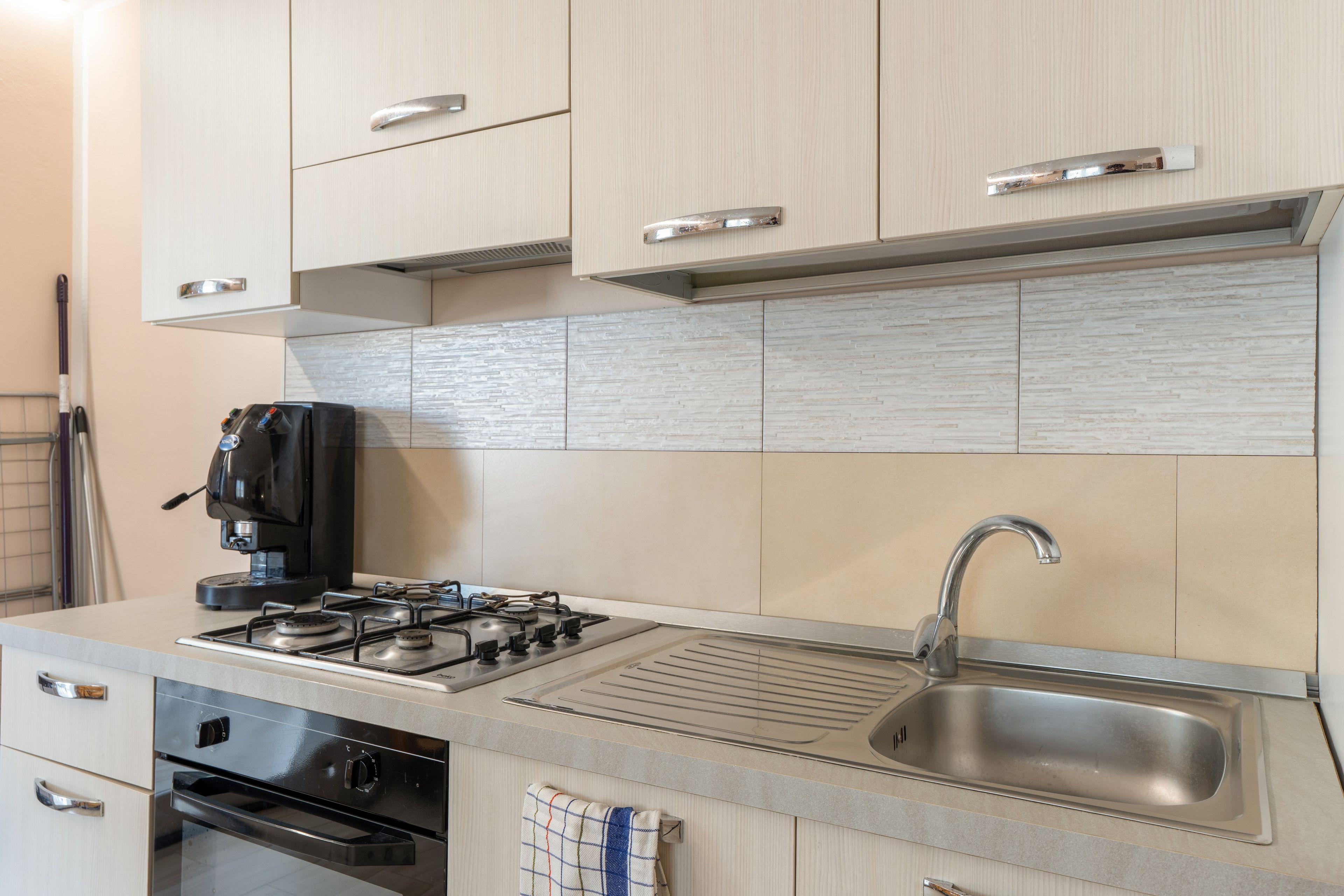Eine moderne Küche mit Edelstahlgeräten, einem Gasherd, einem Backofen und einer Spüle.