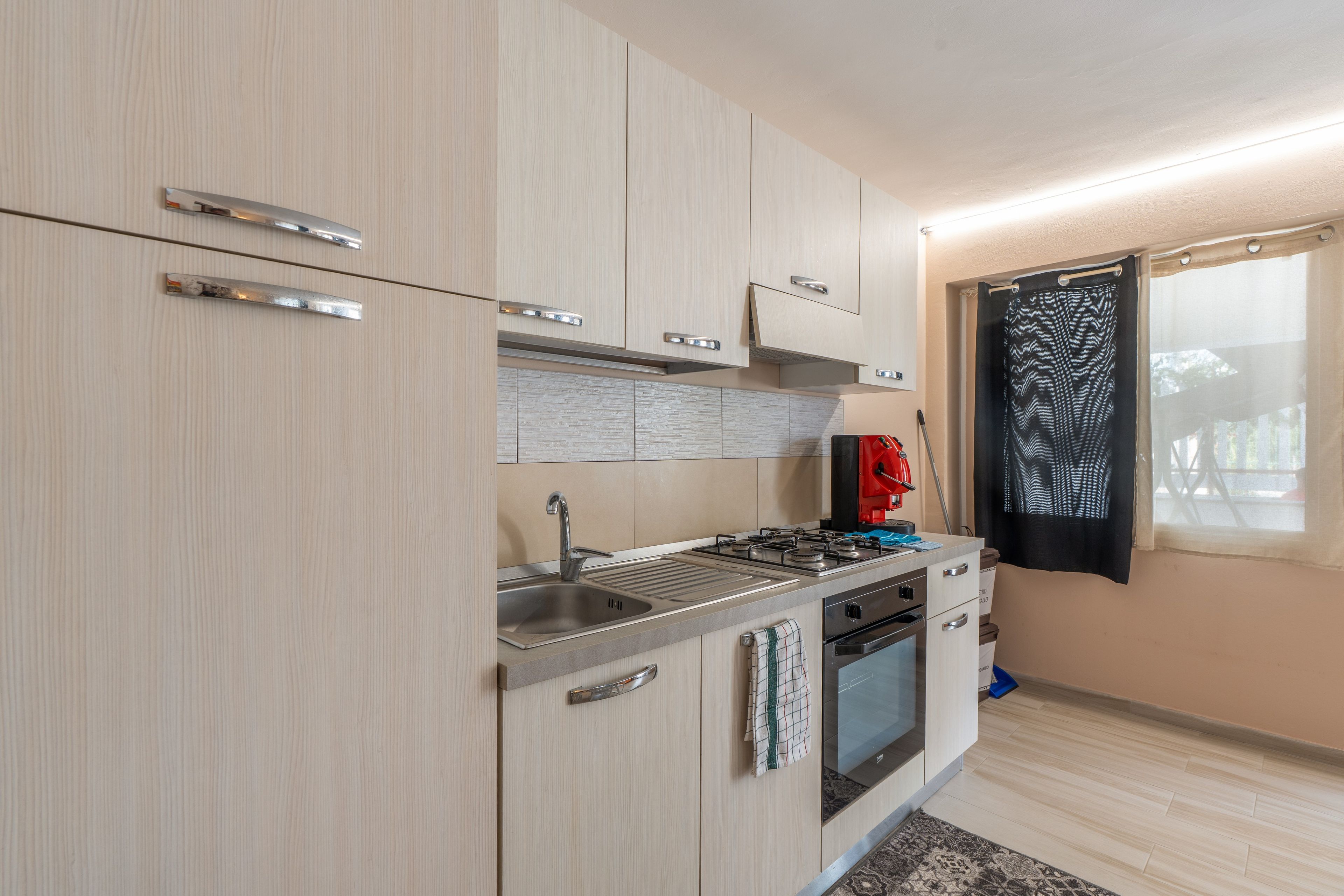 A compact kitchen with a gas stove, a sink, and a built-in oven.