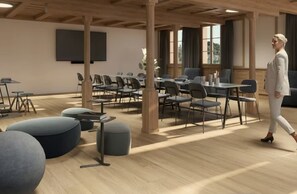 Een ruime vergaderzaal met meerdere tafels en stoelen, een groot scherm en een houten plafond.