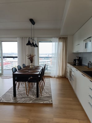 Una cucina moderna con zona pranzo, ampie finestre e vista sulla città.