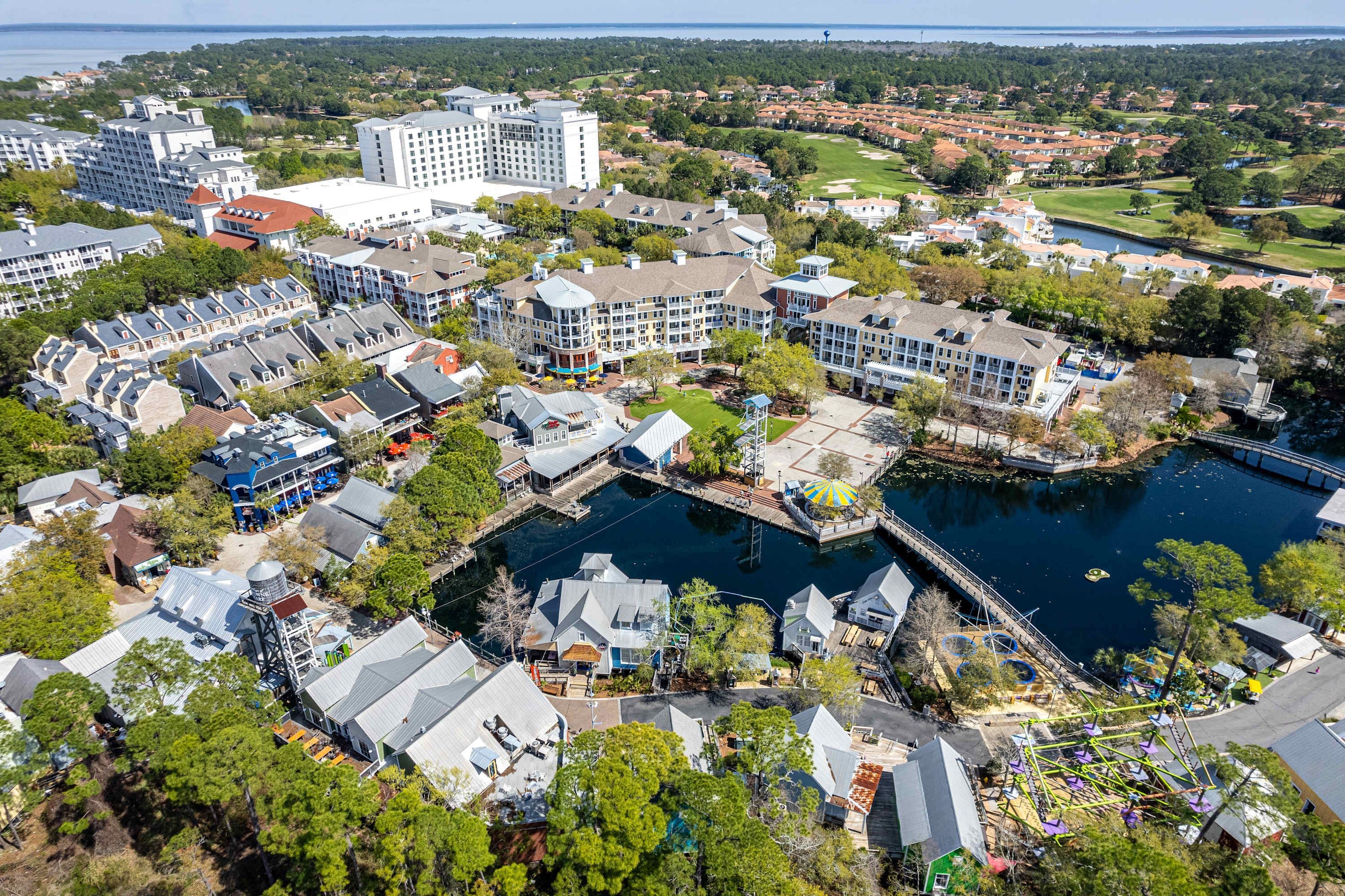 A coastal resort area with multiple buildings, a marina, and a golf course.