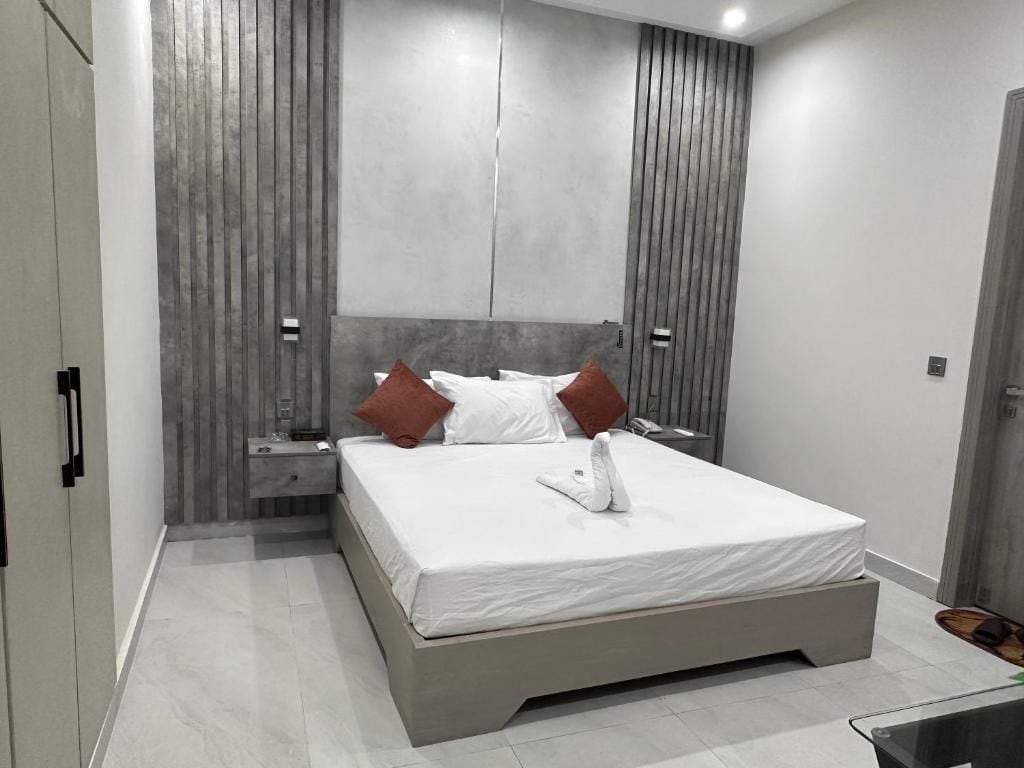Quarto moderno com uma cama grande, uma mesinha de cabeceira e um guarda-roupa.