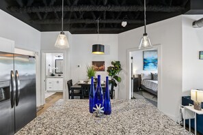 Una cocina moderna con encimera de granito, electrodomésticos de acero inoxidable e iluminación colgante.