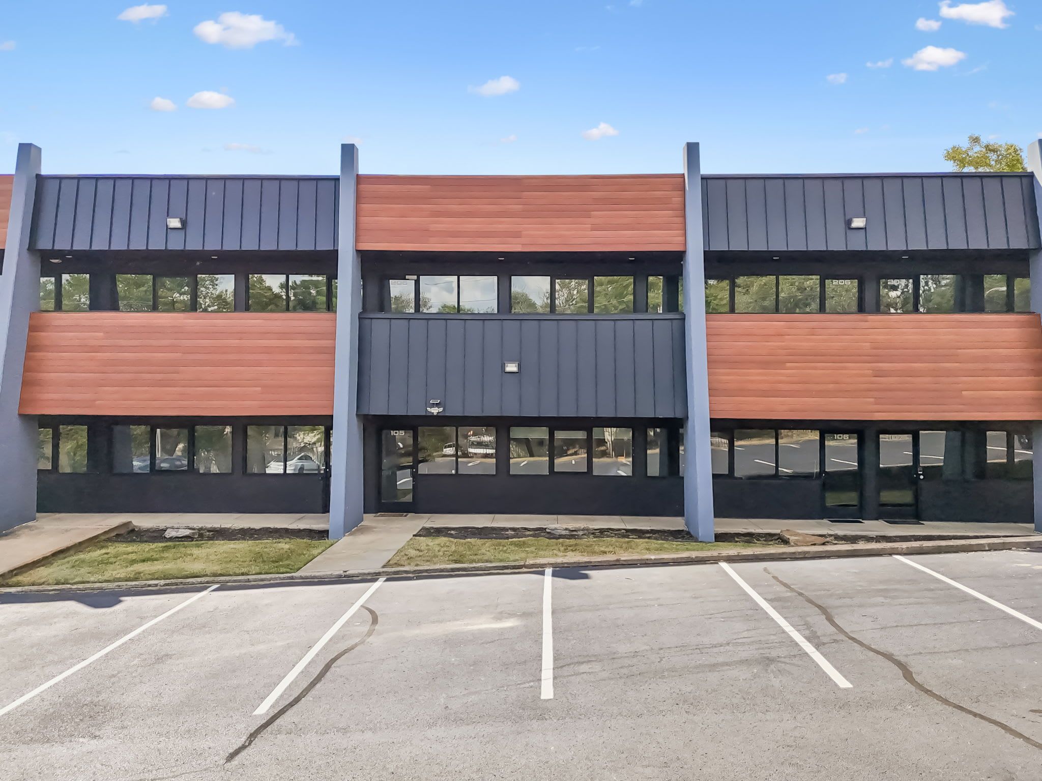 A multi-story building with a parking lot in front.