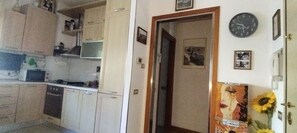 Eine Küche mit Schränken, einer Mikrowelle und einer Uhr an der Wand.