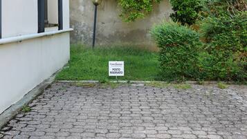 A cobblestone pathway leading to a building with a 'Casa Bonsai' sign indicating a reserved post.
