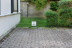 Un sendero adoquinado que conduce a un edificio con un letrero que dice 'Casa Bonsai', indicando un lugar reservado.