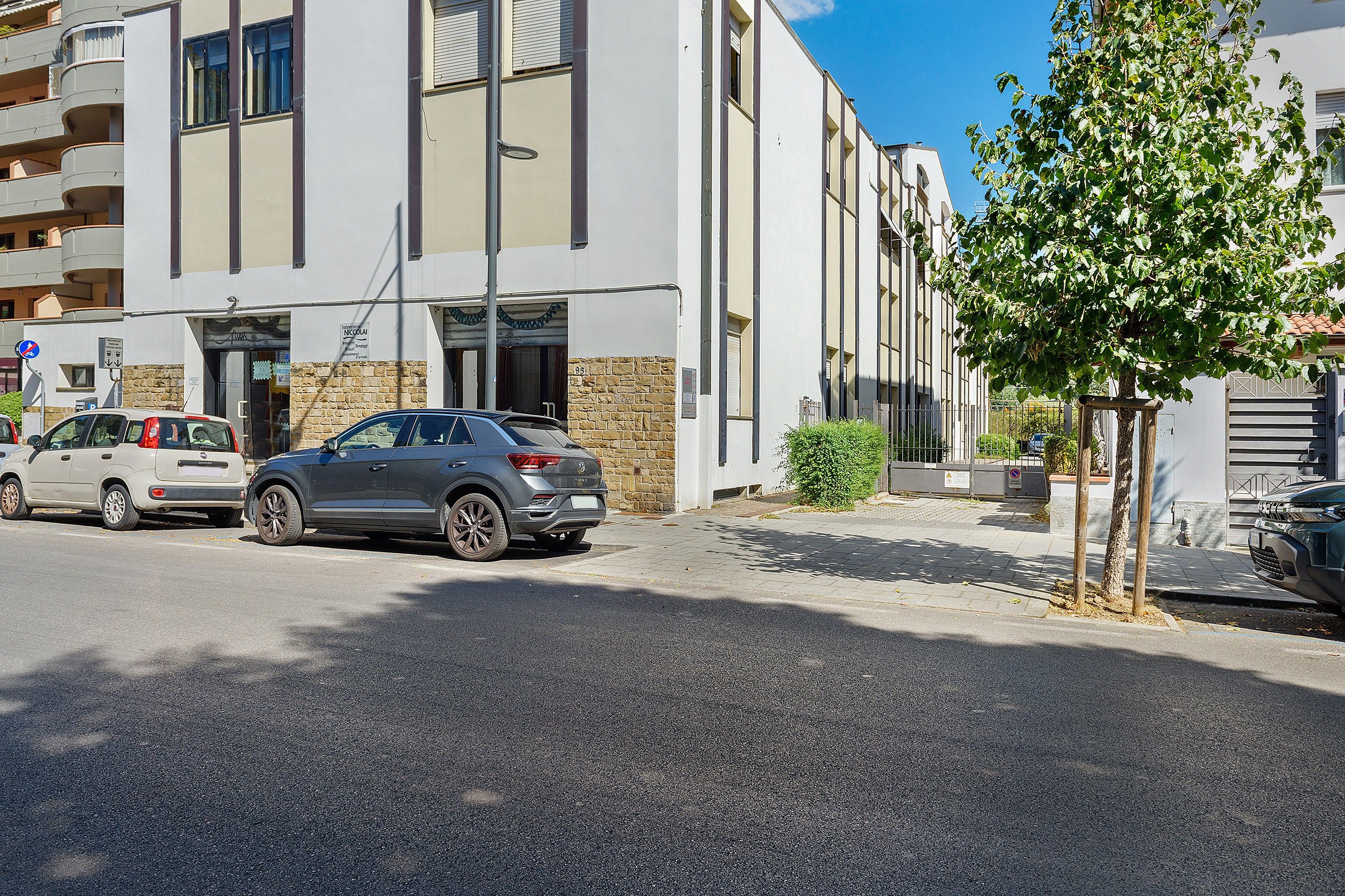 Ein mehrstöckiges Gebäude mit Parkplatz davor.