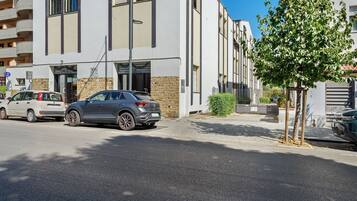 A multi-story building with a parking area in front.